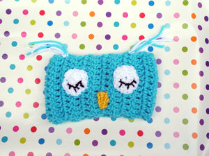 A blue headband with owl eyes and nose on top of a pokka dot background